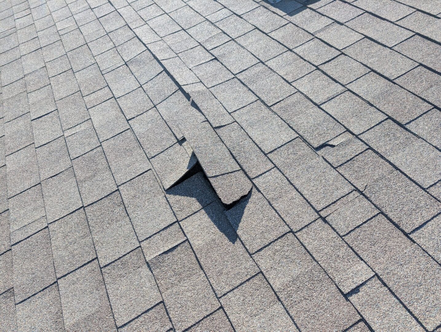 Lifted and damaged asphalt shingles before roof replacement on 68th Circle NE in Otsego, Minnesota